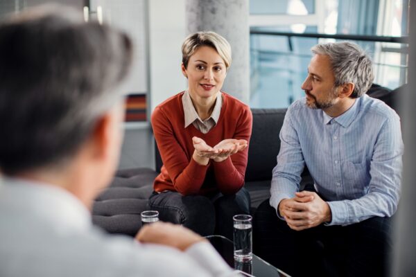 mid-adult-couple-talking-financial-advisor-meeting-office mid-adult-couple-talking-financial-advisor-meeting-office